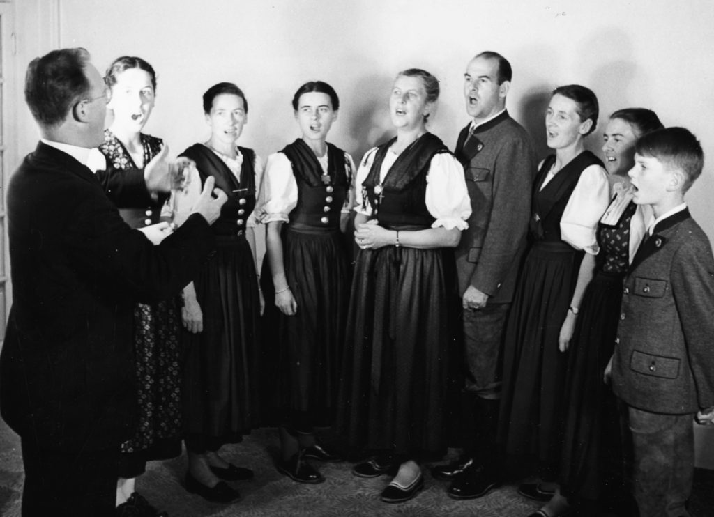 Portrait of the Von Trapp family singing; (L-R) Eleonore, Agatha, Maria, the Baroness, Werner, Hedwig, Martina and Johannes, they are conducted by Father Franz Wasner, London, circa 1950. (Photo by George Konig/Keystone Features/Getty Images)