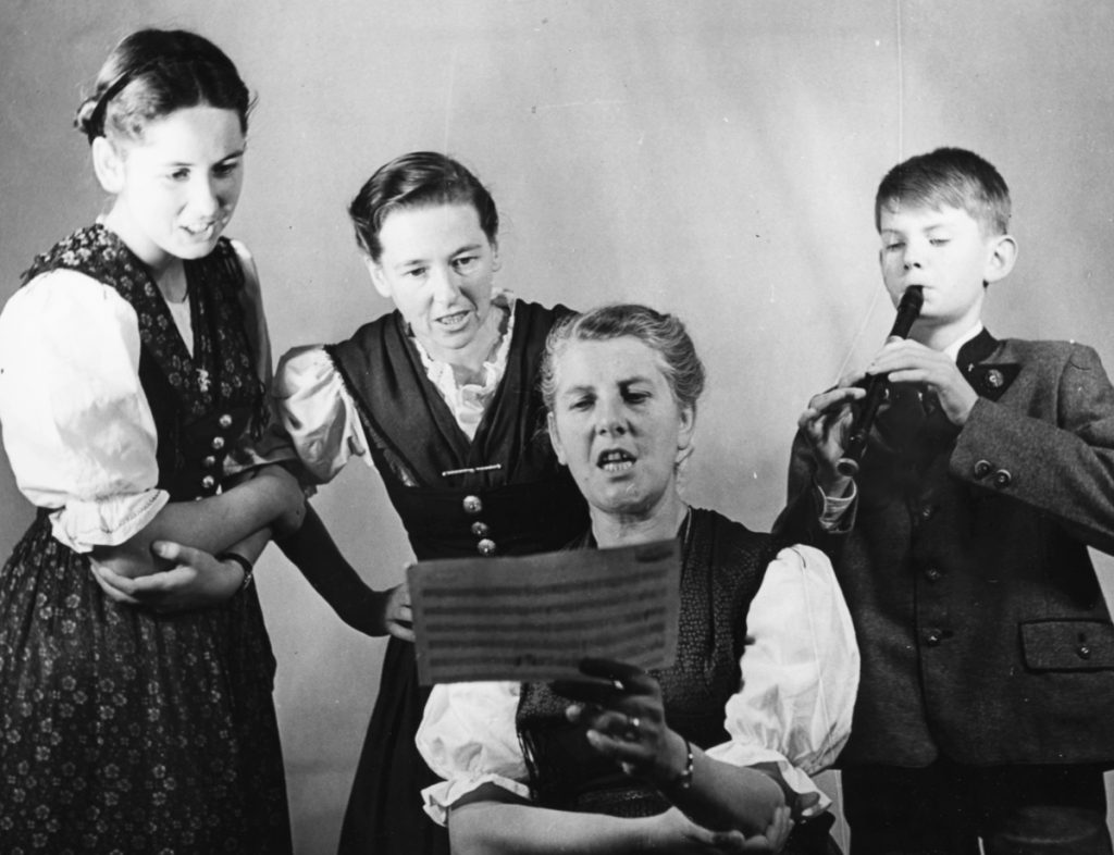 Portrait of Baroness Maria Von Trapp and three of her children, (L-R) Eleonore, Agatha and Johannes, singing from a piece of sheet music, London, circa 1950. (Photo by George Konig/Keystone Features/Getty Images)