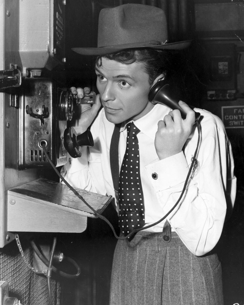 circa 1940: A young Frank Sinatra making a telephone call on the set of the film 'Step Lively'. (Photo by Hulton Archive/Getty Images)