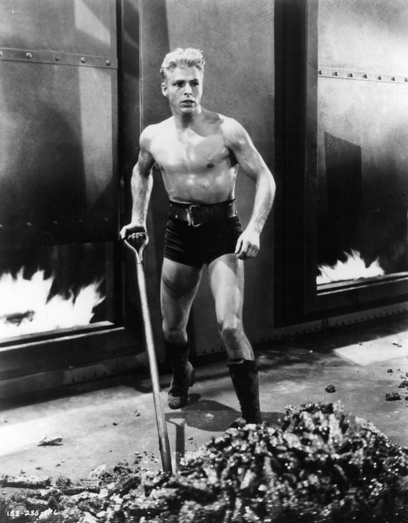 Buster Crabbe shoveling in a scene from the film 'Flash Gordon', 1936. (Photo by Universal/Getty Images)