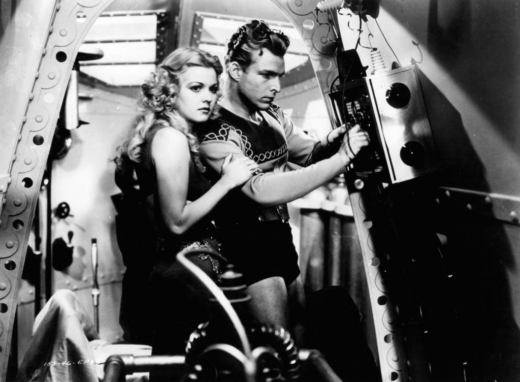 Jean Rogers holding onto Buster Crabbe in a scene from the film 'Flash Gordon', 1936. (Photo by Universal/Getty Images)